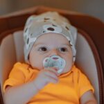 Bebeluș adormit liniștit în pătuț, într-o cameră întunecoasă și călduroasă
